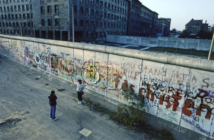 Framed Print : Man photographs a woman at the Berlin Wall