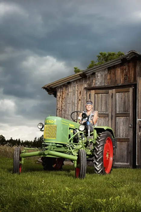 Framed Print : Man with a prosthetic leg driving a vintage tractor