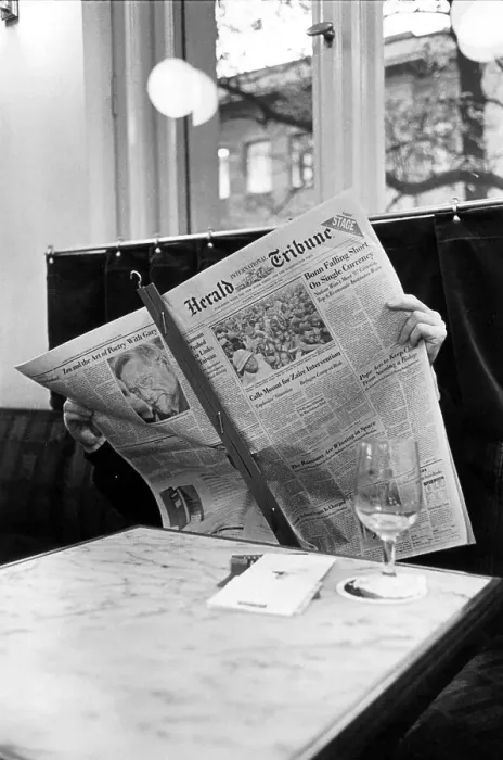 Framed Print : Man reads the Herald Tribune newspaper in a Cafe