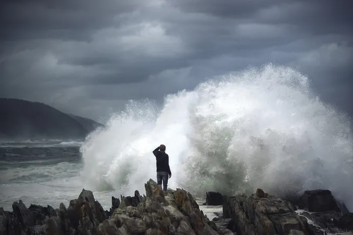 Framed Print : Man on rock in front of breaking wave