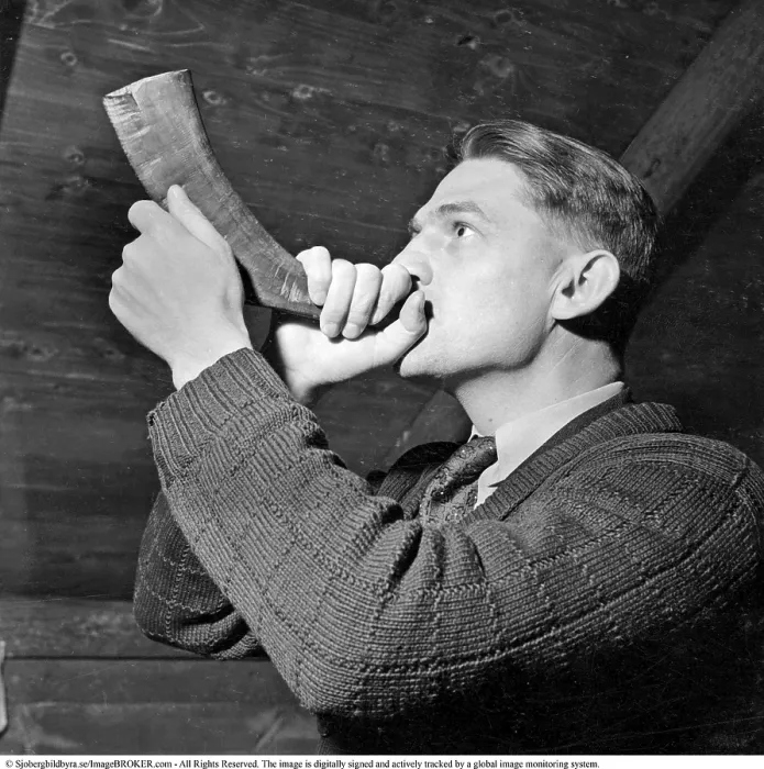 Framed Print : A man is seen blowing into a horn crafted from an animal's horn Framed Print : A man is seen blowing into a horn crafted from an animal's horn