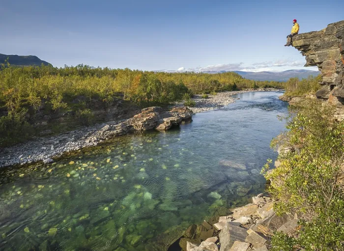 Framed Print : Man sitting on stone cliff over the river Abiskojakka Framed Print : Man sitting on stone cliff over the river Abiskojakka