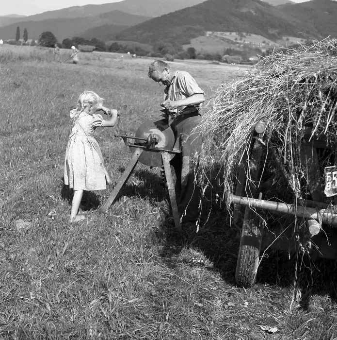 Framed Print : Man standing at the grindstone and girl cranked