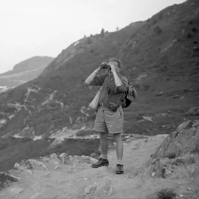 Framed Print : Man standing on a mountain path looking through binoculars Framed Print : Man standing on a mountain path looking through binoculars