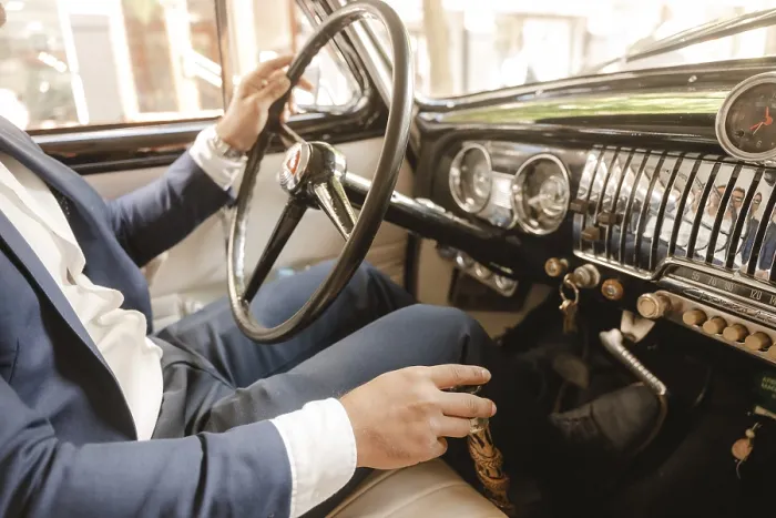 Framed Print : A man in a suit is driving a car with a black steering wheel