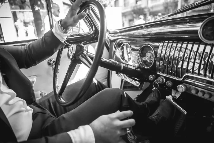 Framed Print : A man in a suit is driving a vintage car