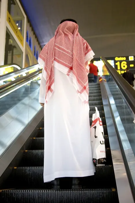 Framed Print : Man in traditional white Arabian dressed on automatic ladder Framed Print : Man in traditional white Arabian dressed on automatic ladder