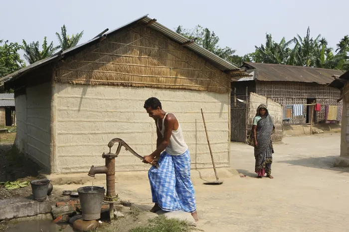 Framed Print : Man using hand pump in village, Assam, India NOMR