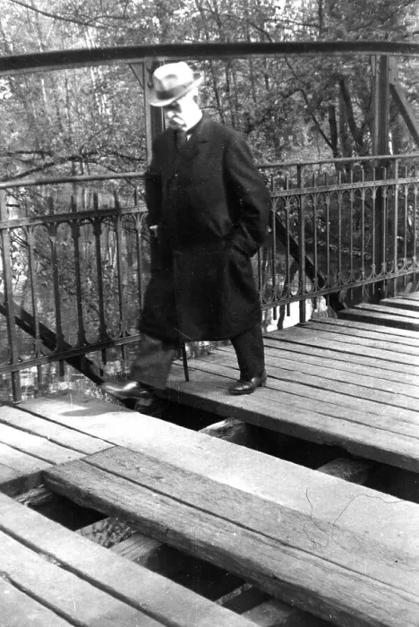 Framed Print : A man with walking stick and hat crosses a broken bridge
