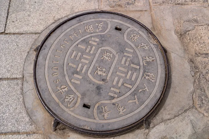 Framed Print : A manhole cover inscribed in Chinese in the courtyard of Kumbum Champa Ling Monastery