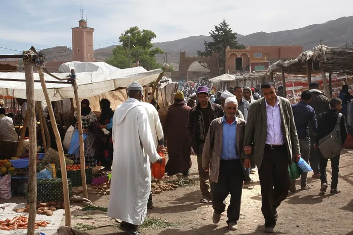 Framed Print : Market scene in Msemrir with people walking along the stalls