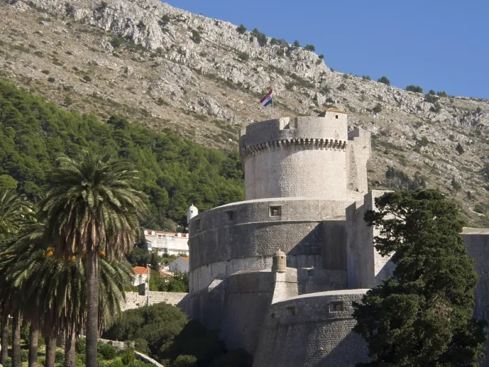 Framed Print : Massive medieval fortress with a national flag on a hill surrounded by trees Framed Print : Massive medieval fortress with a national flag on a hill surrounded by trees