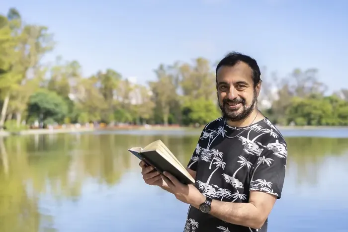 Framed Print : Mature man reading by a lake, enjoying free time on a sunny day