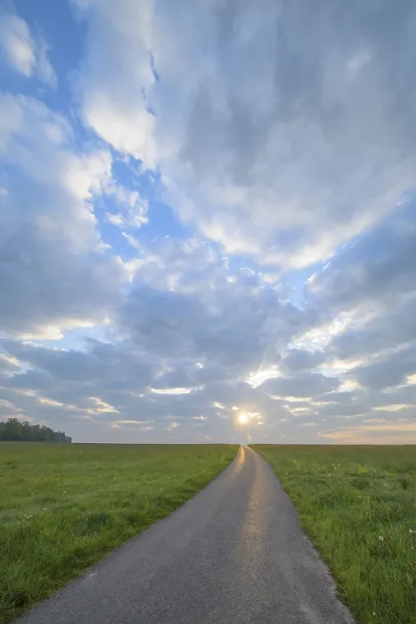 Framed Print : Meadow with road at sunrise