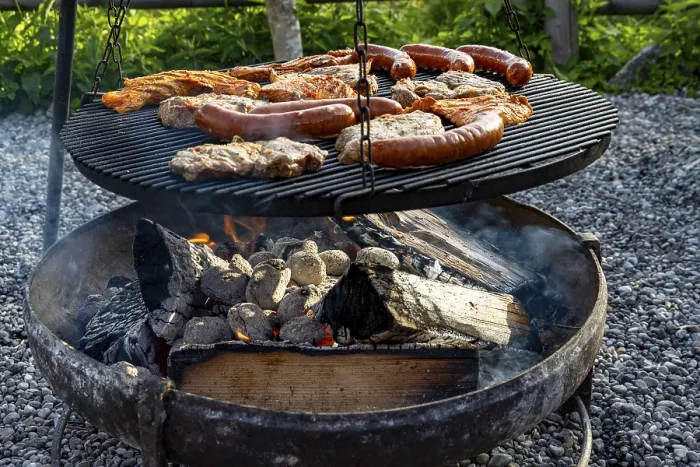 Framed Print : Meat and sausages on the grill over a fire bowl during a barbecue