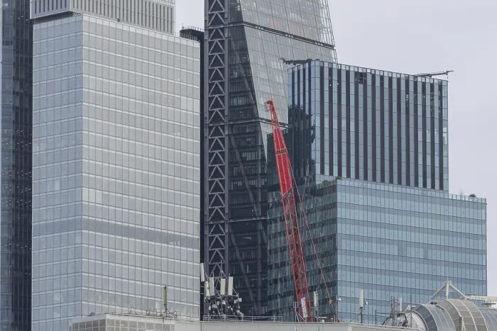 Framed Print : Mechanical red crane on a building in front of skyscrapers
