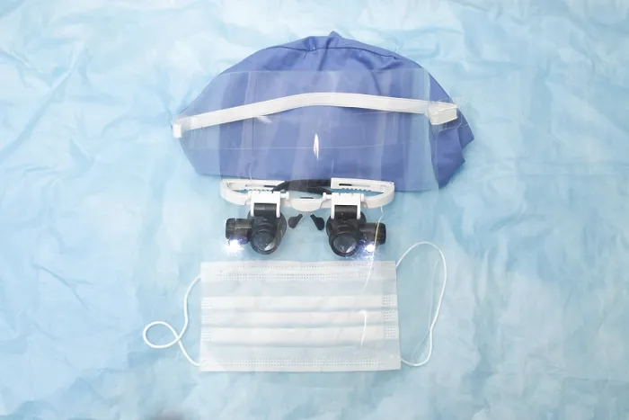 Framed Print : Medical equipment including mask and cap on blue background