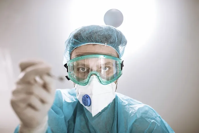 Framed Print : A medical professional in protective gear holding a tool