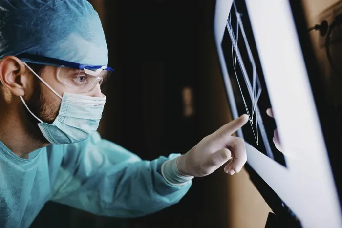 Framed Print : A medical staff member focusing on a screen displaying data in a protected setting