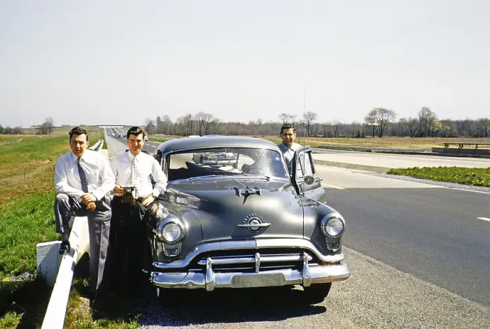 Framed Print : Three men in business suits standing next to an Oldsmobile 88 on a motorway, USA around 1953