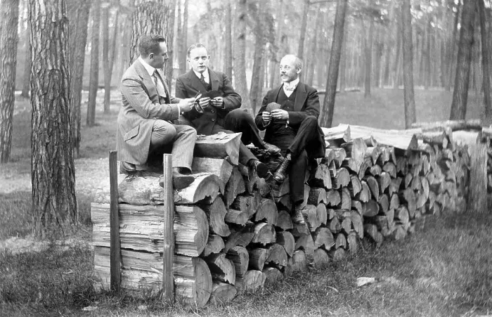Framed Print : Men sitting on a wood pile, historical photo