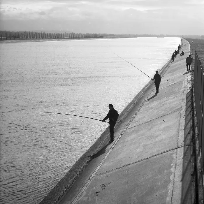 Framed Print : Men standing on the banks of a river and fishing