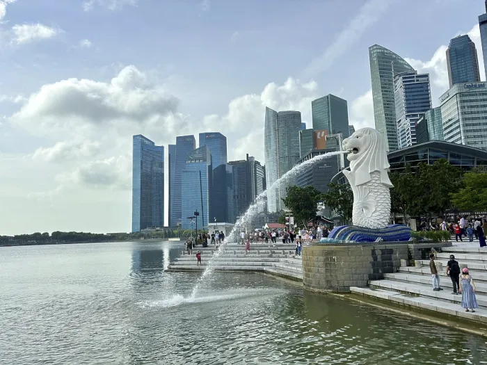 Framed Print : Merlion fountain spouts water in front of the impressive skyline and clouds