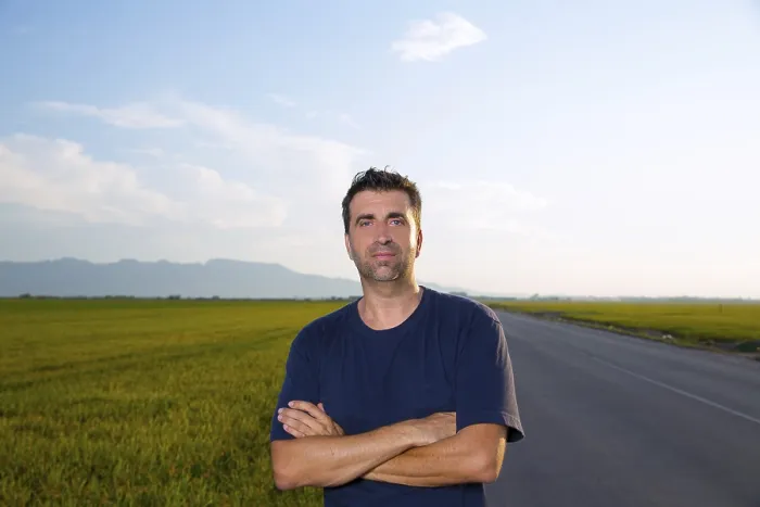 Framed Print : Mid age man in road at meadows posing with crossed arms cereal fields