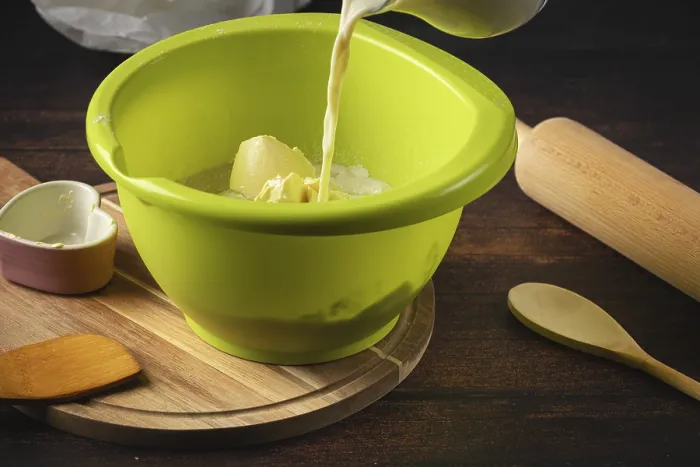 Framed Print : Milk is poured into a green bowl with other baking ingredients