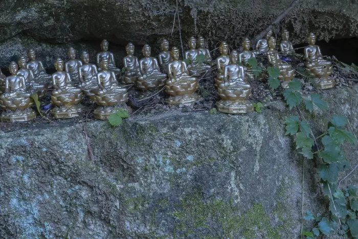 Framed Print : Miniature sitting Buddhas on ledge of boulder in mountainous public park in South Korea