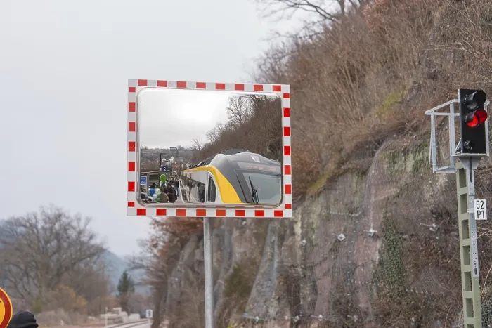 Framed Print : A mirror depicts a train and people waiting in a landscape