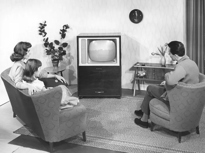 Framed Print : A model family in front of the television in a model living room