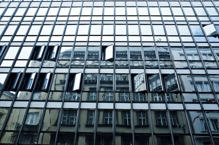 Framed Print : A modern building with a glass facade reflecting older architecture