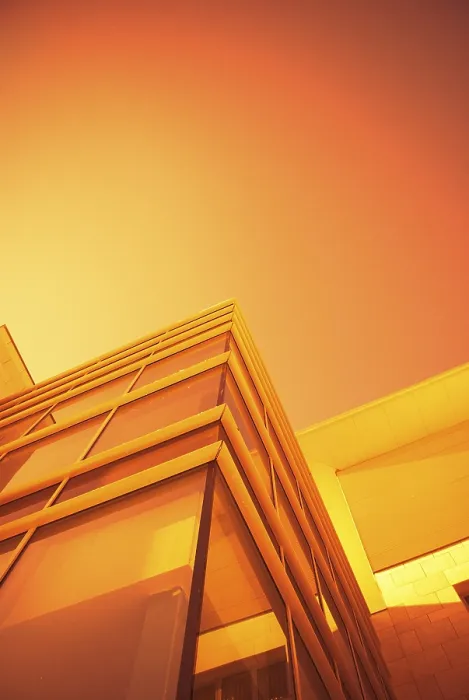 Framed Print : A modern building with glass surfaces under an orange sky Framed Print : A modern building with glass surfaces under an orange sky