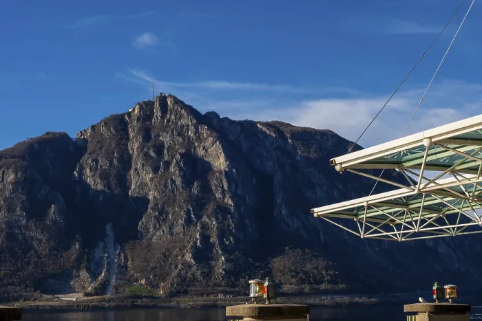 Framed Print : Modern Building Roof Against Blue Sky and Mountain Peak San Salvatore on Lake Lugano in Campione d'Italia