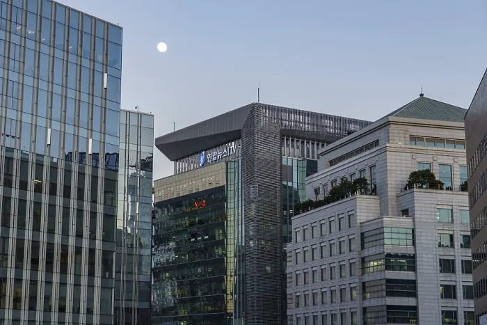 Framed Print : Modern buildings with glass facades under an evening sky with a moon Framed Print : Modern buildings with glass facades under an evening sky with a moon