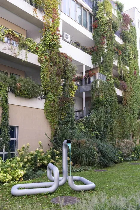 Framed Print : Modern facade with lush greenery and a sculpture in the front garden