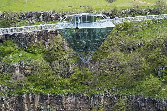 Framed Print : Modern glass bridge crosses green gorge with trees and rocks