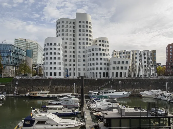 Framed Print : Several modern high-rise buildings and boats in a harbour under a grey sky