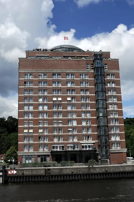 Framed Print : Modern hotel building on a riverside with blue sky and clouds