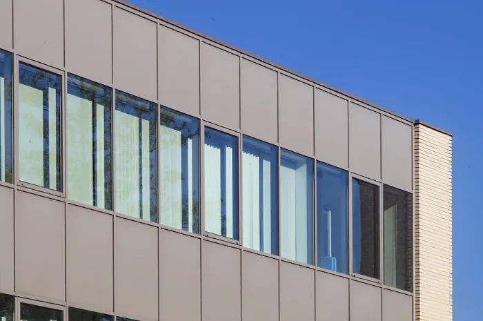 Framed Print : Modern office building exterior showcasing a contemporary design with large windows reflecting the vibrant blue sky