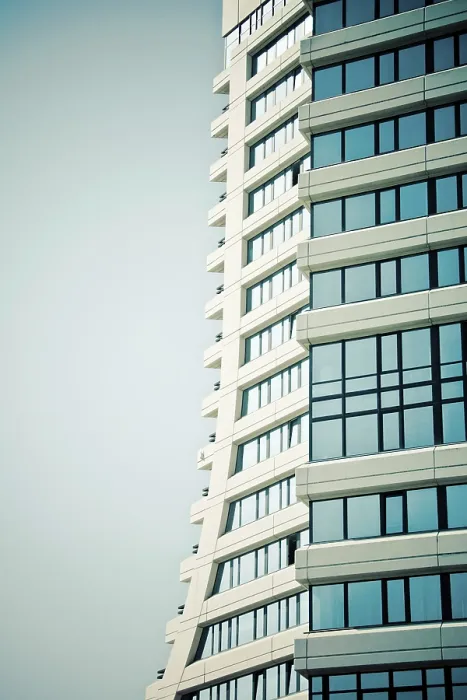 Framed Print : Modern skyscraper with a curved design and blue glass windows against a clear sky