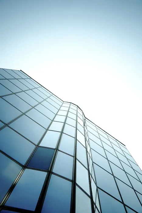 Framed Print : Modern skyscraper with glass windows reflecting a gradient blue sky in a sleek vertical design