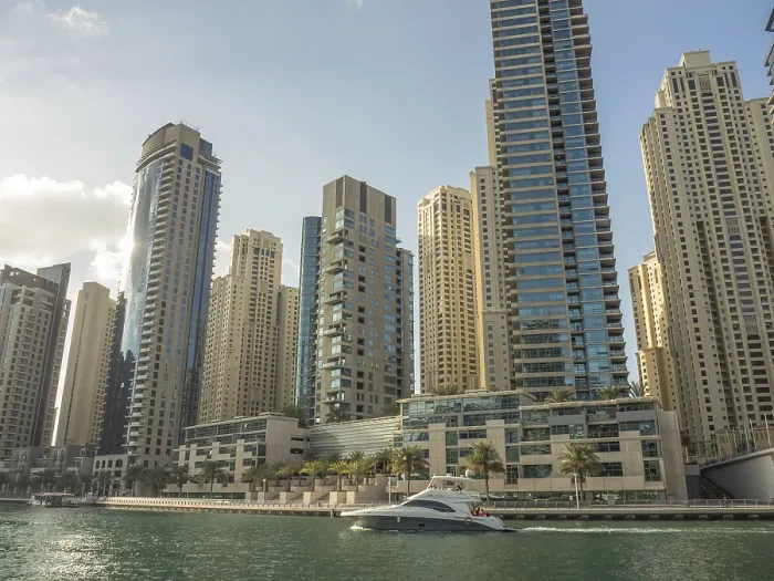Framed Print : Modern skyscrapers and a boat on a city waterway under the sun