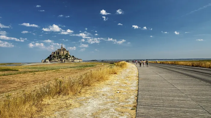 Framed Print : The monastery of Mont Saint-Michel in the distance under a clear sky and slightly cloudy