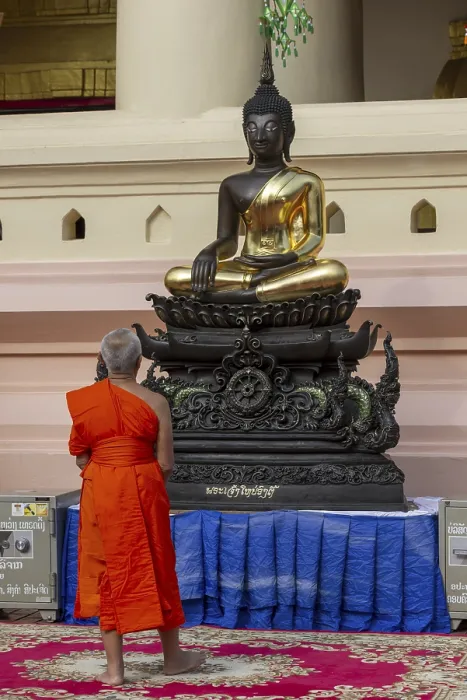 Framed Print : Monk in front of a Buddha statue