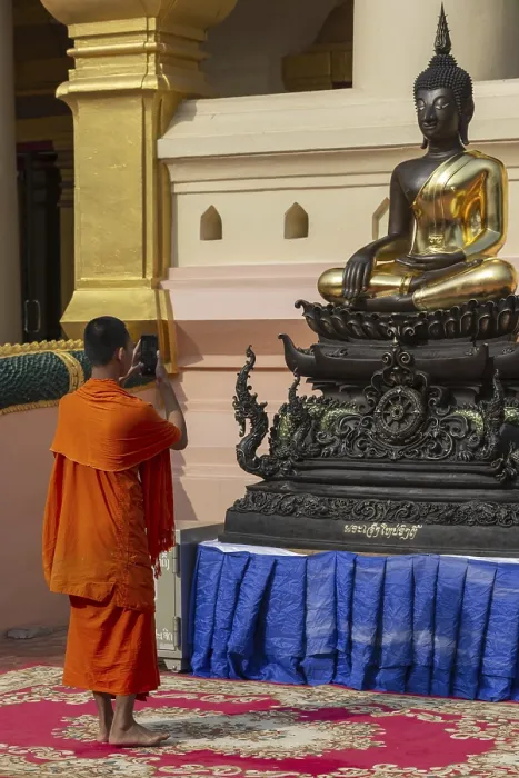 Framed Print : Monk in front of a Buddha statue