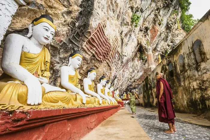 Framed Print : Monk looking at the seated Buddha statues Framed Print : Monk looking at the seated Buddha statues