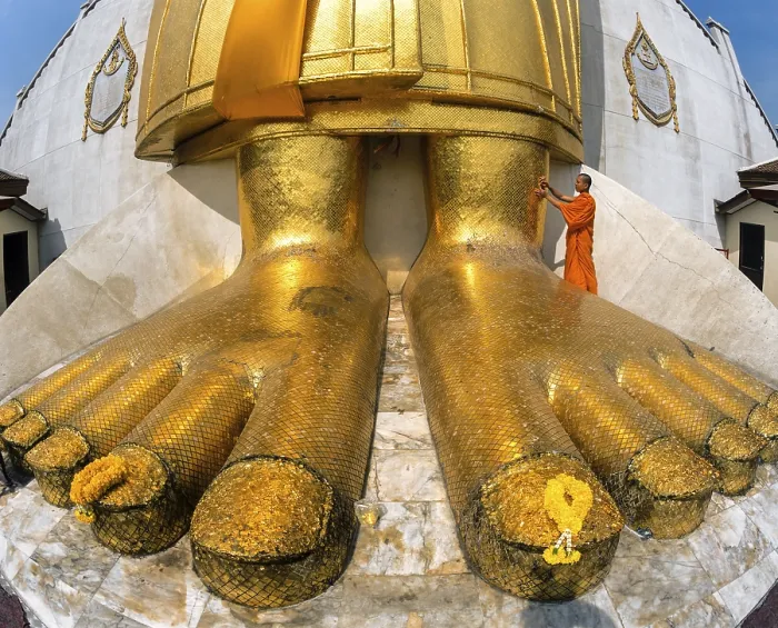 Framed Print : Monk praying at the feet of the golden Buddha statue of Wat Intharawihan