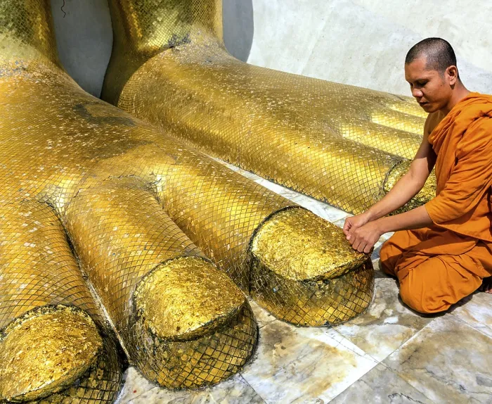 Framed Print : Monk praying at the feet of the golden Buddha statue of Wat Intharawihan